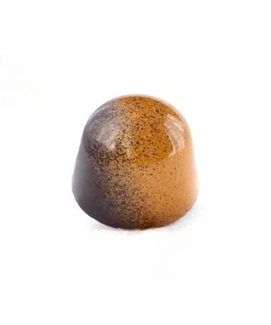 Side view of a tan and brown gourmet chocolate truffle that tastes like brown butter caramel