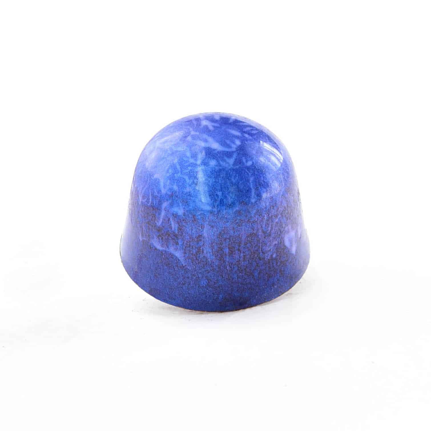 Side view of a bright blue gourmet chocolate truffle with brown swirls; truffle tastes like sweet coconut and almonds