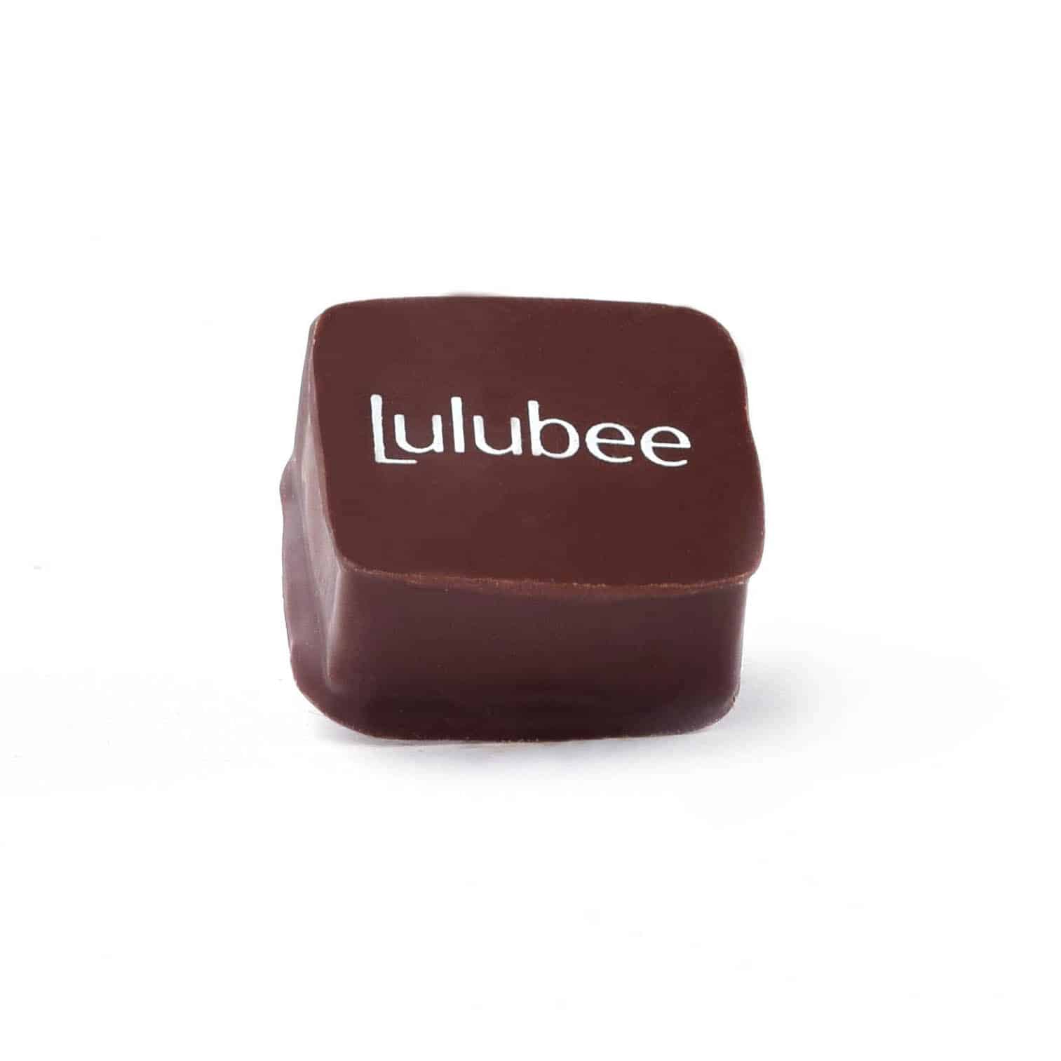 Side view of a gourmet dark chocolate truffle that has the Lulubee logo on it