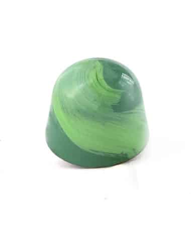 Side view of a green gourmet chocolate truffle with a lighter green brush stroke; truffle tastes like mint