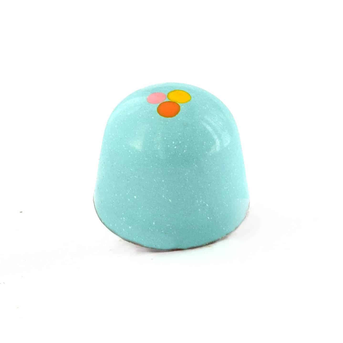 Side view of a blue gourmet bonbon with an orange, pink, and yellow dot; truffle tastes like peanut butter and pretzels