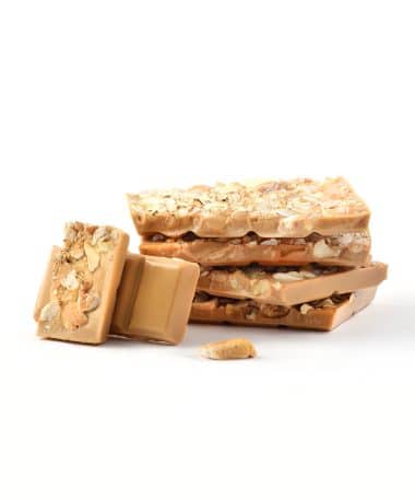 Vertical stack of Caramelized White Chocolate and Cashew Gourmet Chocolate Bar with two pieces facing the front