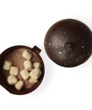 Ornament-shaped dark chocolate bomb; opened cocoa bomb reveals the gourmet sipping chocolate inside