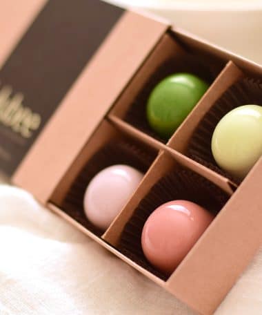 12-piece box of pastel-colored gourmet chocolate truffles in a kraft box with a label that reads Lulubee Artisanal Chocolate