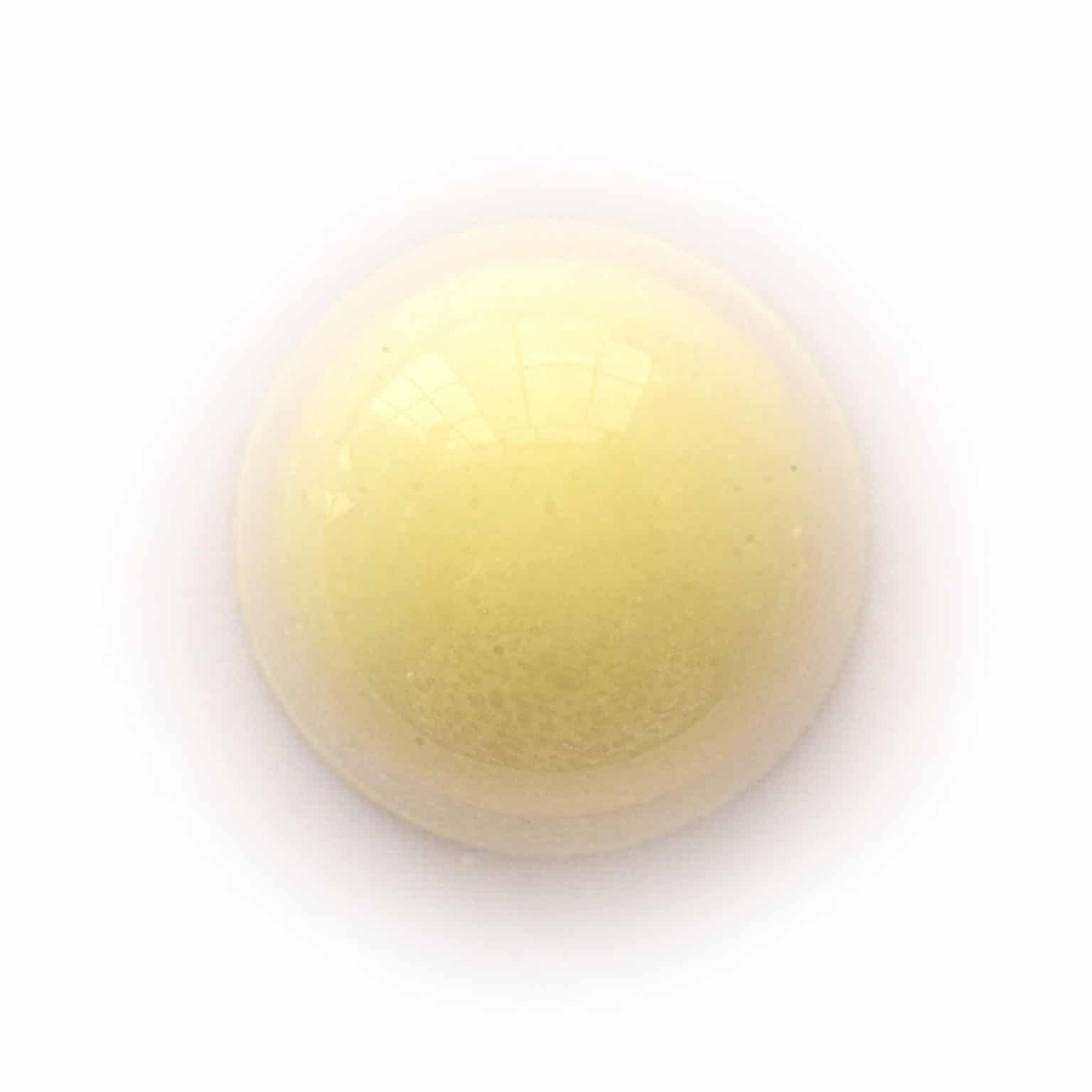 Overhead view of pale yellow gourmet chocolate truffle that tastes like passion fruit