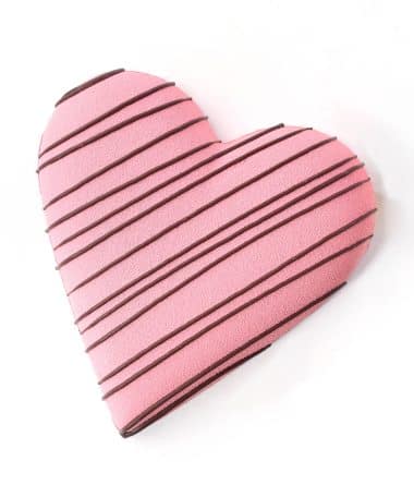 Large gourmet milk chocolate Valentine Heart filled with caramel, peanut butter, and pretzels. Heart is pink with dark chocolate stripes. Gluten-free