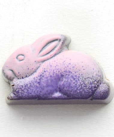 Overhead view of a pink and purple gourmet chocolate truffle in the shape of a rabbit and tastes like peanut butter
