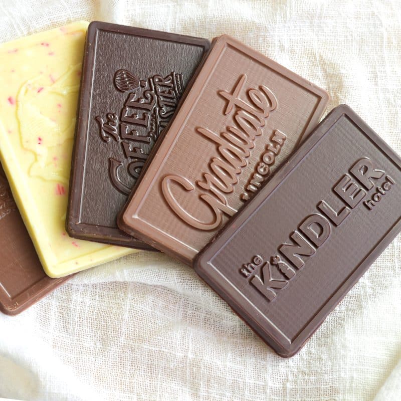 Five mini gourmet chocolate bars with different embossed logos on each one
