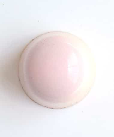 Overhead view of a pale pink gourmet truffle that contains raspberry jelly and lemon ganache
