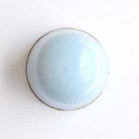 Overhead view of a pale blue gourmet truffle that contains a layer of mascarpone ganache and a layer of coffee ganache