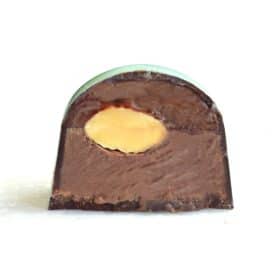 Inside view of a gourmet truffle that contains dairy-free caramel, a whole almond, and ground almond gianduja