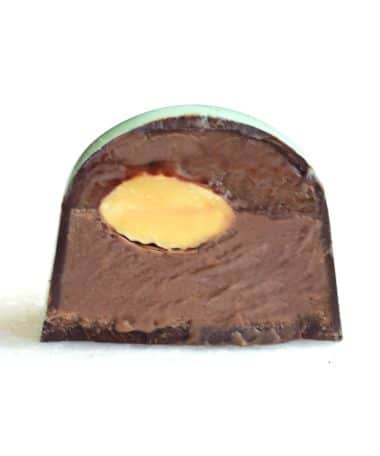 Inside view of a gourmet truffle that contains dairy-free caramel, a whole almond, and ground almond gianduja