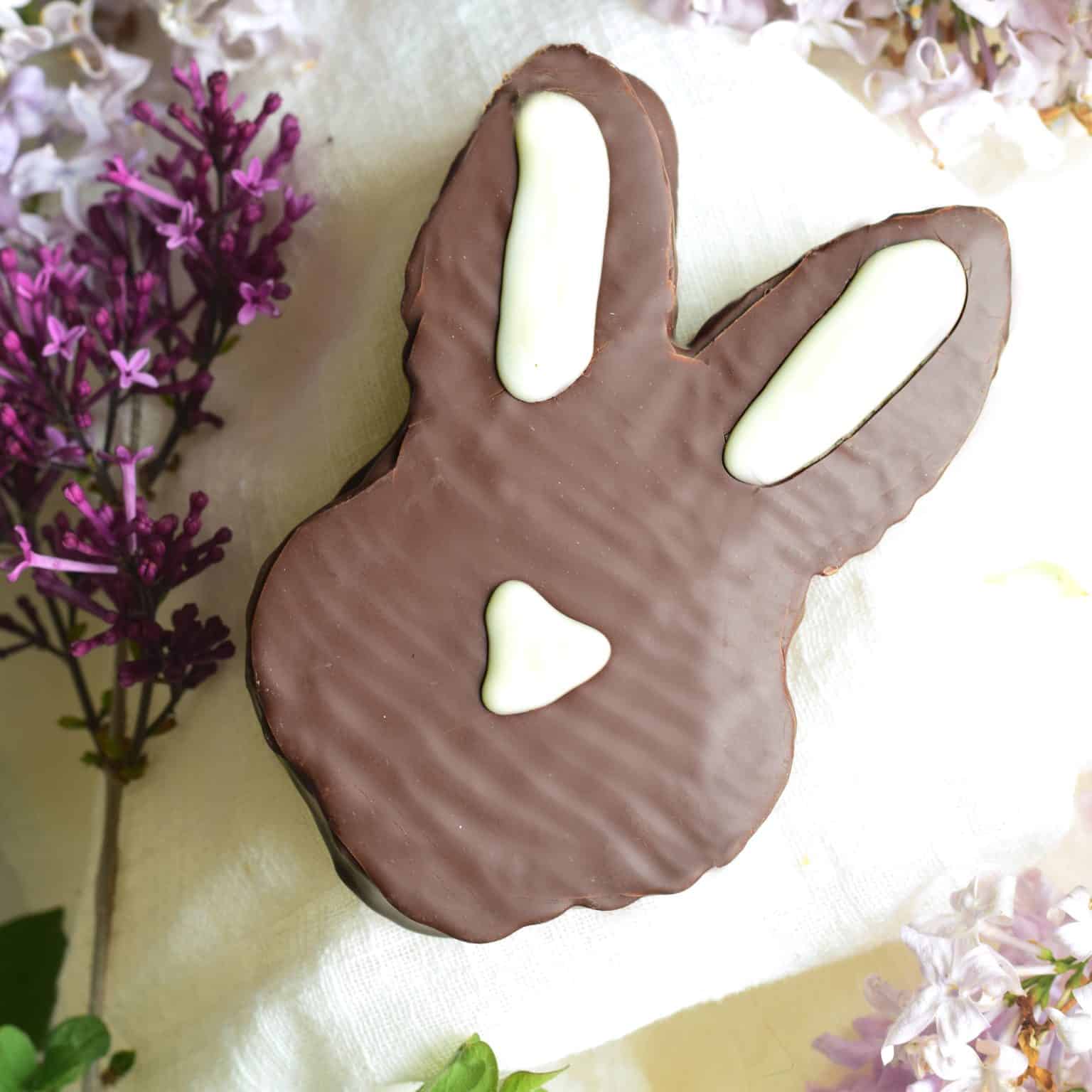 Head-shaped Easter bunny that is covered in gourmet dark chocolate and filled with vanilla bean marshmallow. white chocolate is piped to represent the ears and nose.