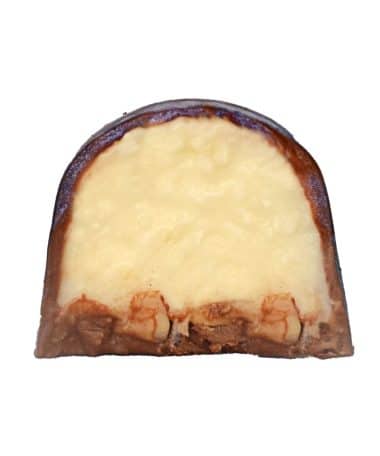 Inside view of a gourmet chocolate truffle that contains a thick layer of coconut ganache and a thin layer of almond pieces