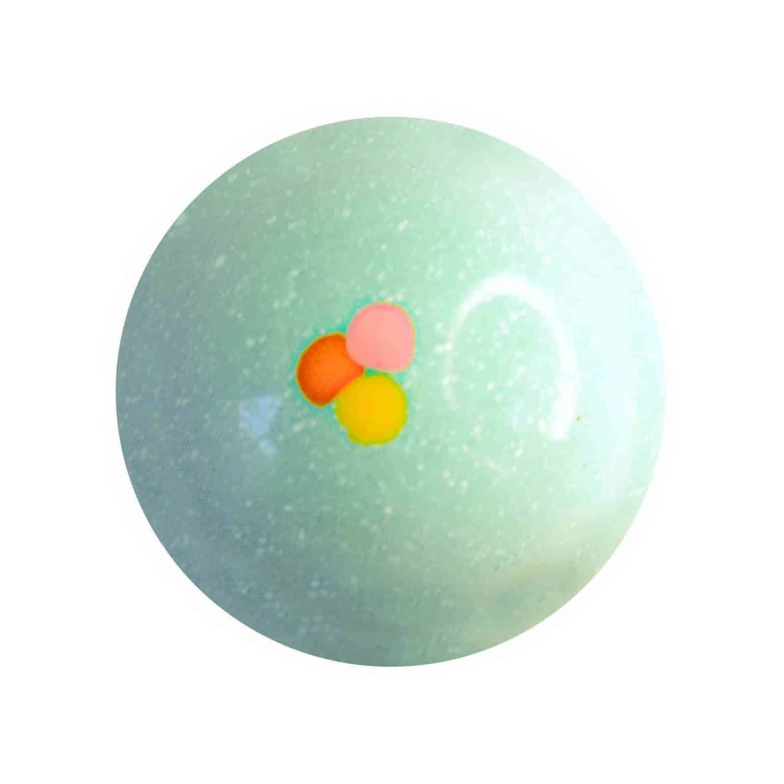 Overhead view of a pale blue gourmet bonbon with an orange, pink, and yellow dot in the center