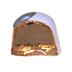 Inside view of a light purple gourmet truffle that contains a thick dark blueberry caramel layer and a thin oat crisp layer