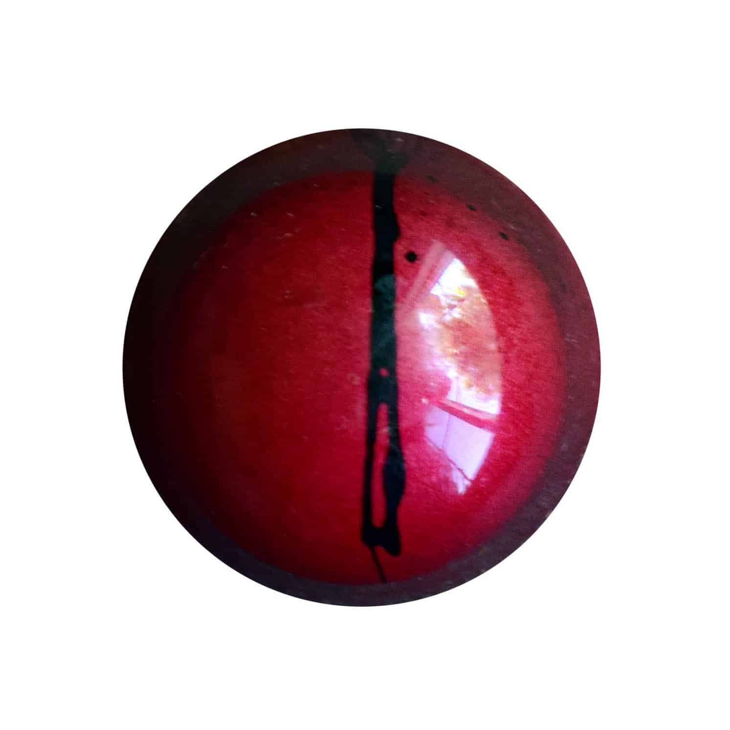 Overhead view of a red gourmet chocolate truffle with a black dotted line that is off-center; the truffle tastes like strawberry and balsamic