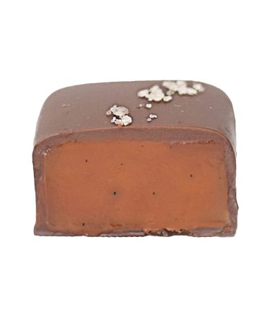 Inside view of a gourmet dark chocolate truffle that contains caramel; truffle is sprinkled with sea salt