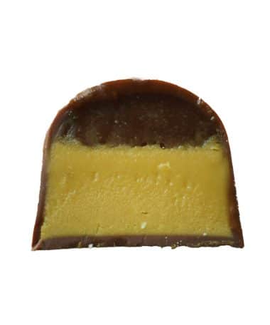 Inside view of a gourmet truffle that contains a layer of salted caramel and a layer of white chocolate caramel corn ganache