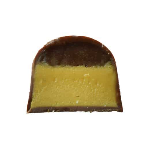 Inside view of a gourmet truffle that contains a layer of salted caramel and a layer of white chocolate caramel corn ganache