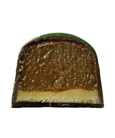 Inside view of a gourmet chocolate truffle that is filled with a cookie crust topped with cinnamon apple caramel ganache