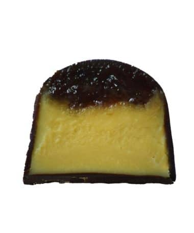Inside view of a gourmet chocolate truffle that is filled with a layer of house-ground peanut butter ganache topped with a dollop of strawberry jelly