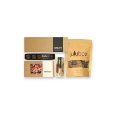 Five packages of artisanal treats in kraft-colored packaging; contains a 12-piece box of bonbons, a 5-piece box of Sea Salt Caramels, an artisanal chocolate bar, a package of wrapped, handcrafted caramels, and a large package of gourmet English toffee.