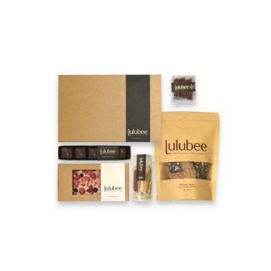 Five packages of artisanal treats in kraft-colored packaging; contains a 24-piece box of bonbons, a 5-piece box of Sea Salt Caramels, an artisanal chocolate bar, a package of wrapped, handcrafted caramels, a large package of gourmet English toffee, and a package of three pecan turtles.