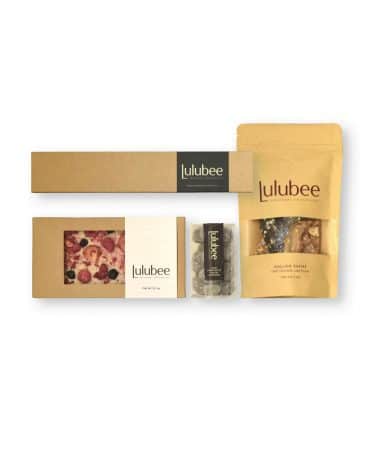 Four packages of artisanal treats in kraft-colored packaging; contains a 6-piece box of bonbons, and artisanal chocolate bar, a package of fine confections, and a package of gourmet English toffee.
