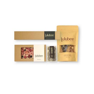 Four packages of artisanal treats in kraft-colored packaging; contains a 6-piece box of bonbons, and artisanal chocolate bar, a package of fine confections, and a package of gourmet English toffee.