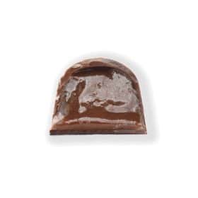 Inside view of a gourmet truffle that contains a soft, buttery caramel mixed with warm holiday spices in a dark chocolate shell