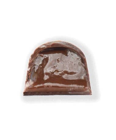 Inside view of a gourmet truffle that contains a soft, buttery caramel mixed with warm holiday spices in a dark chocolate shell