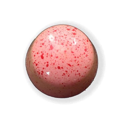 Overhead view of a pink gourmet truffle with white speckles that contains a fresh mint ganache and crunchy peppermint candy