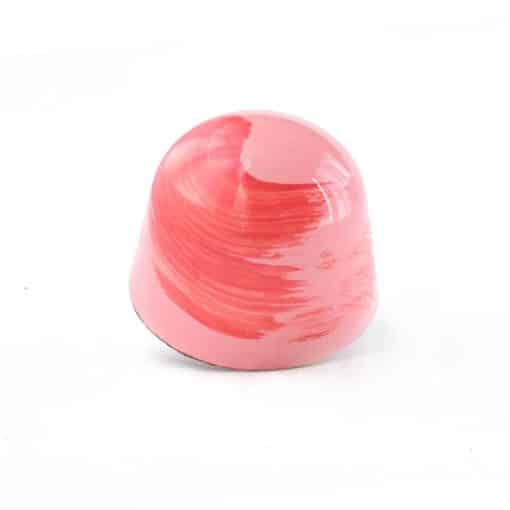 Side view of a pink gourmet chocolate truffle with a dark pink brush stroke; truffle tastes like strawberry and rhubarb