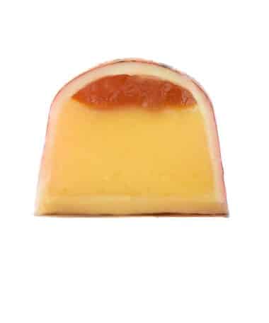 Inside view of a gourmet chocolate truffle with a thick layer of passion fruit ganache and a thin layer of passion fruit jam