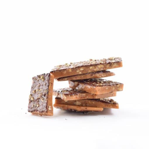 Stack of the best Pecan English Toffee with one piece resting against the stack so you can see the pecans on top of the toffee