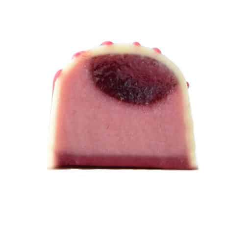 Inside view of a gourmet chocolate truffle with a thick layer of raspberry ganache and a thin layer of raspberry jelly