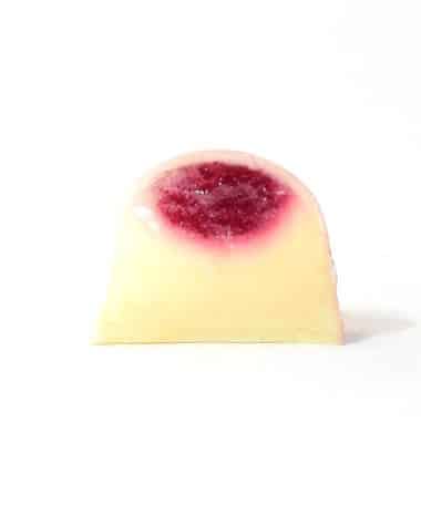 Inside view of a gourmet truffle with a top layer of raspberry jelly and a bottom layer of lemon ganache