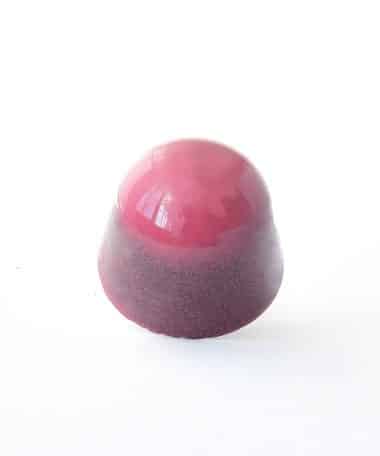 Berry-colored gourmet chocolate truffle that tastes like strawberry cheesecake